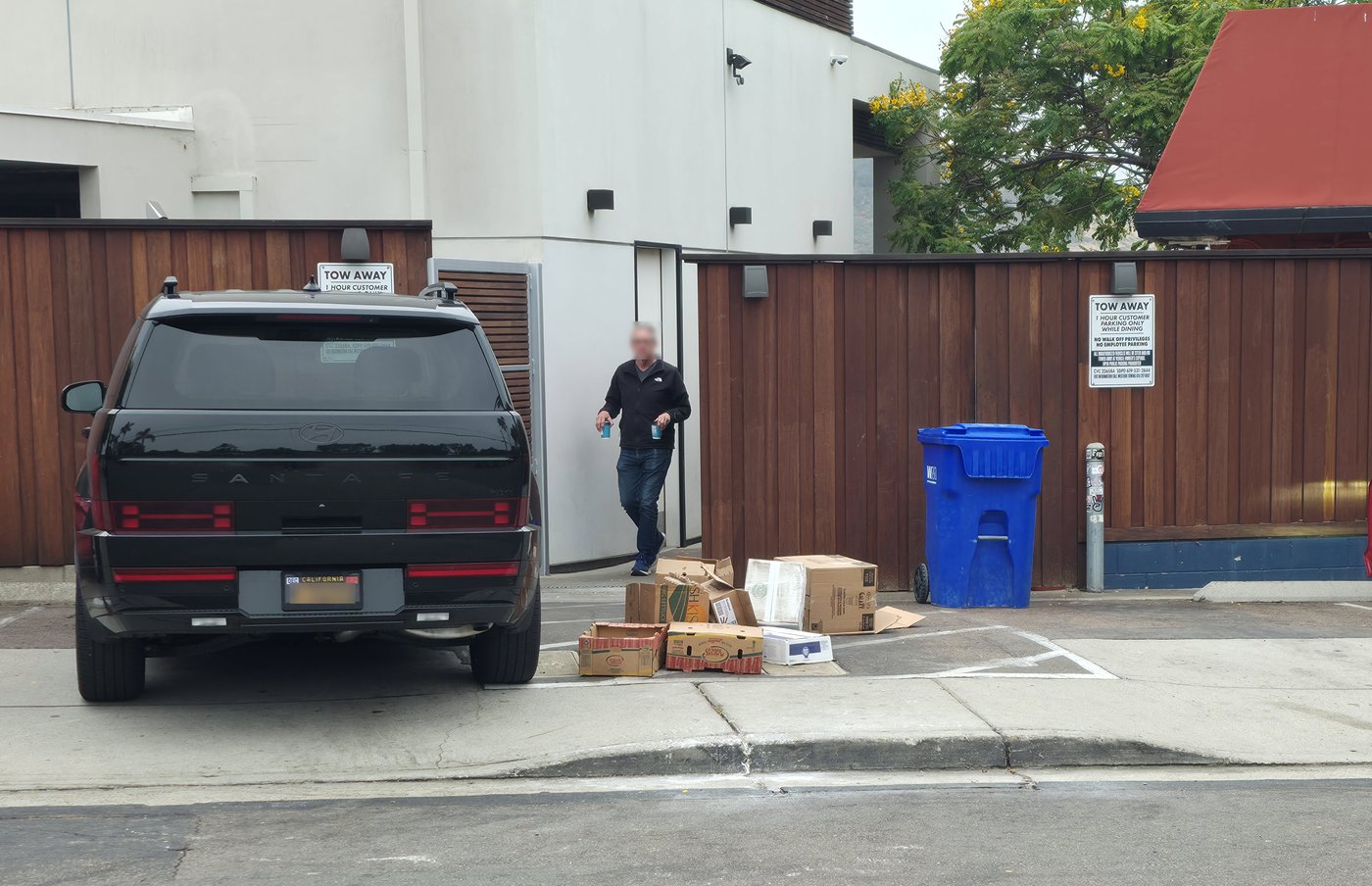 July 10, 2026, 8:33 a.m.: cardboard and produce boxes strewn across the walkway toward the street.